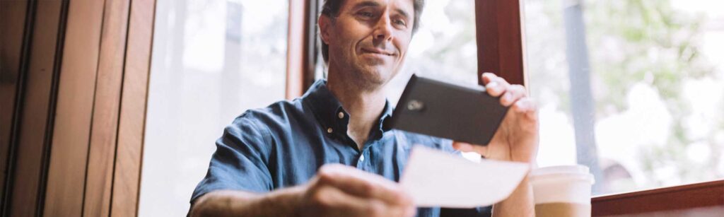 man depositing check with mobile phone