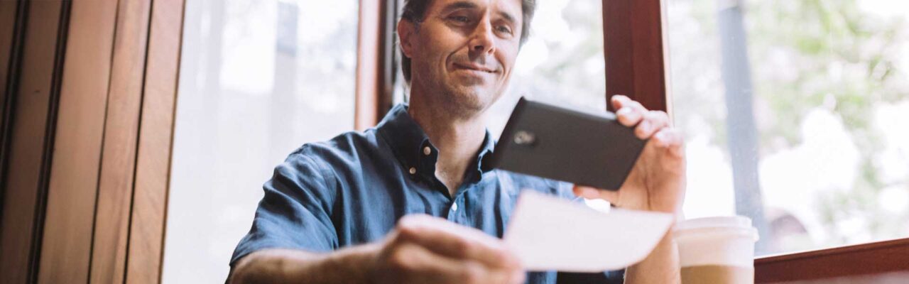 man depositing check with mobile phone