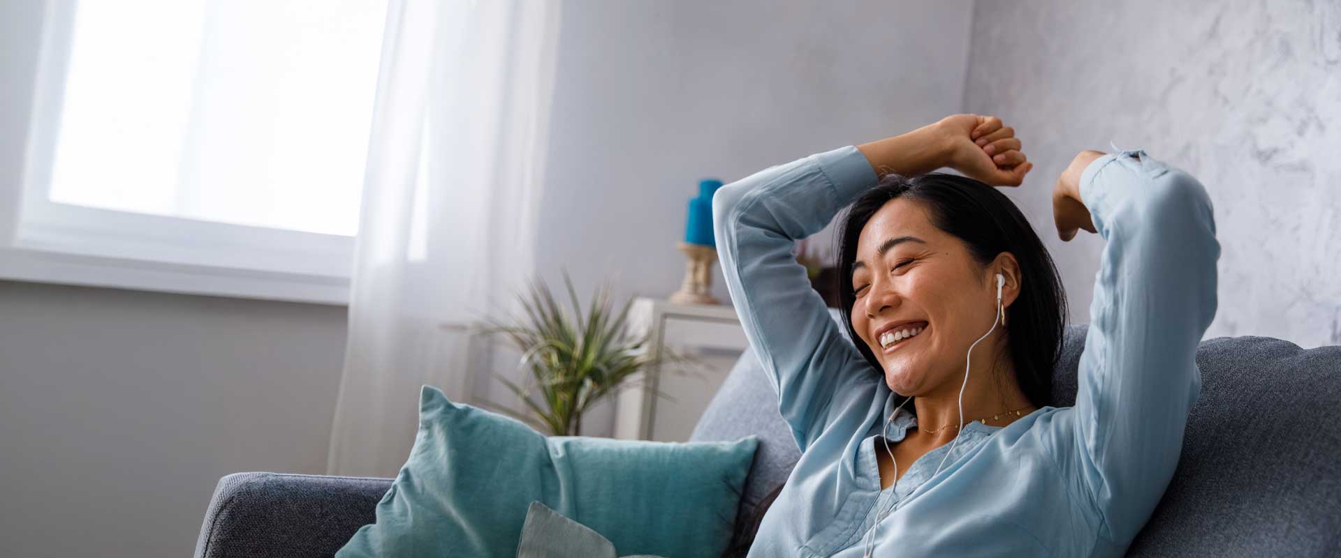 women on couch listening to music and happy because she has a free checking account